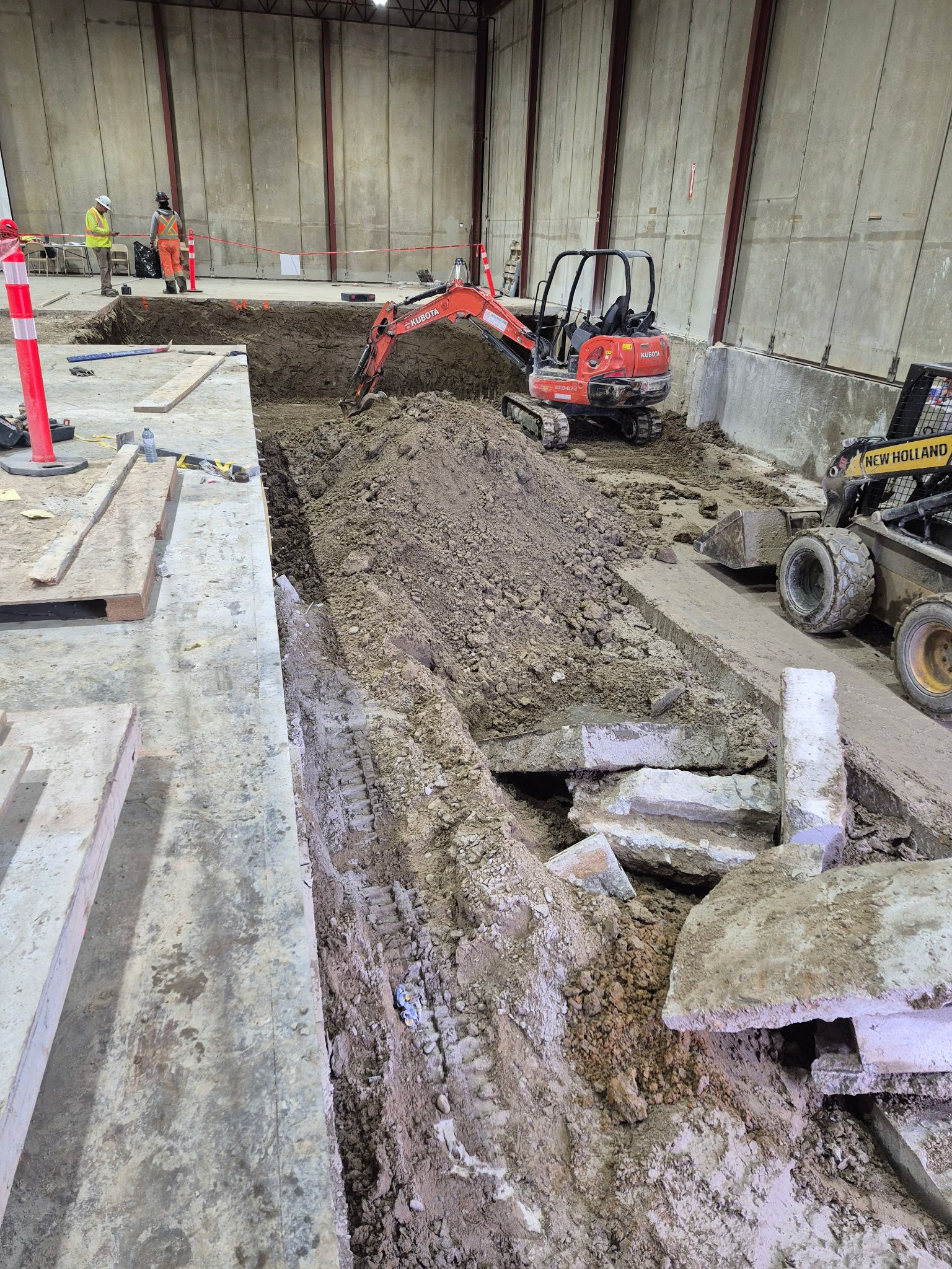 Compact breaker removing a section of reinforced concrete floor slab inside a building