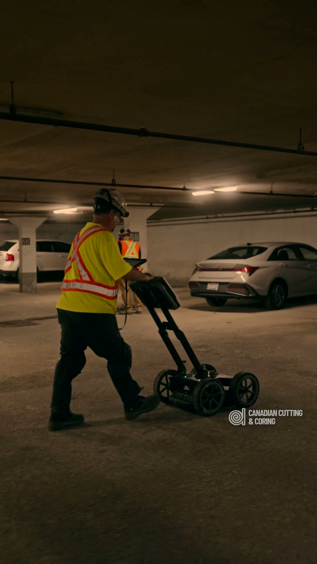 Canadian Cutting & Coring technician running a GPR cart across a concrete floor to locate embedded steel and utilities before cutting