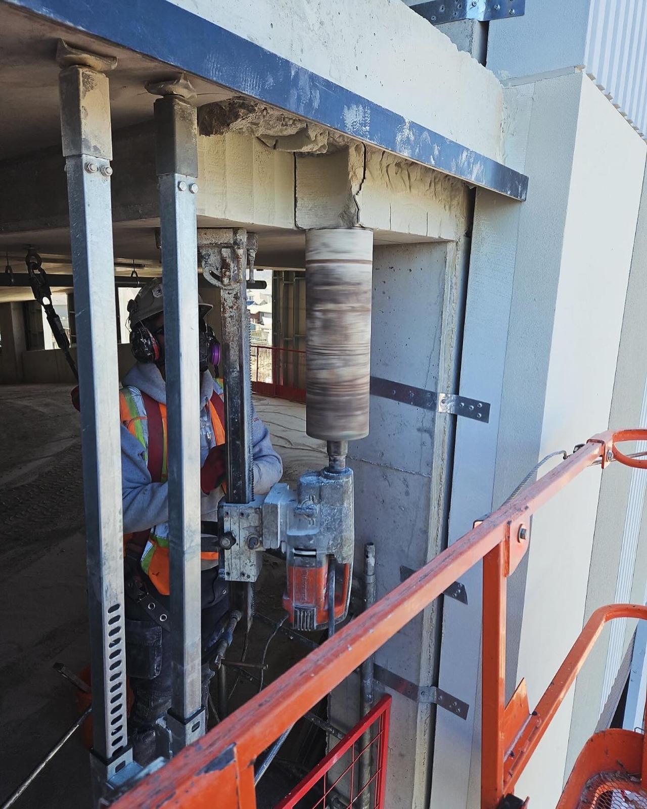 Inverted core drilling rig boring an overhead hole through a concrete ceiling