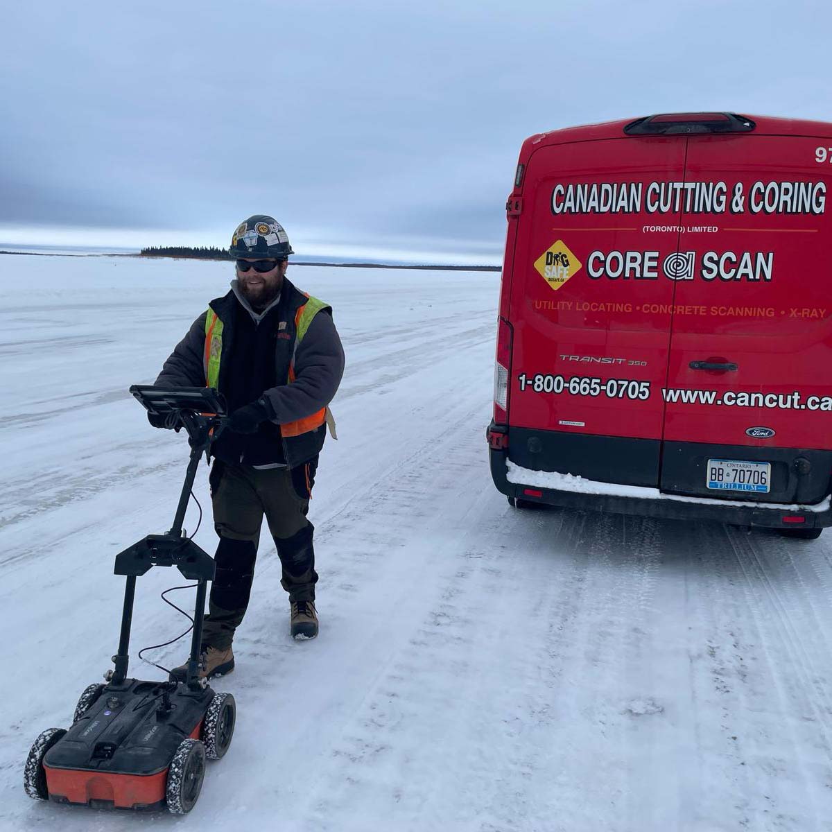 Technician using a low-frequency locator to trace a buried utility line across a site